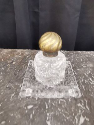 un gros plan sur une petite bouteille en verre avec un bouchon doré