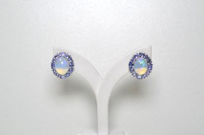 une paire de boucles d'oreilles en oplite et diamants, présentée sur un socle blanc