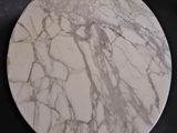 a white marble table with a marble top on a table