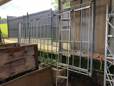 une clôture métallique située à côté d'une caisse en bois