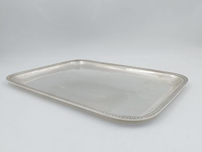un plateau rectangulaire en argent, avec un bord perlé sur fond blanc