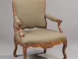 an old chair with a wooden frame and upholstered upholstered seat