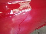 the red paint is peeling off of the front of a car