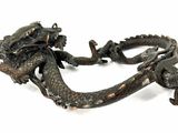 a metal dragon that is sitting on a white surface