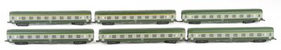 six green and white train cars sitting on top of a white surface
