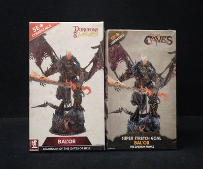 deux boîtes contenant chacune des figurines représentant un démon et un autre démon, sur fond noir