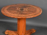 a wooden table with a round top and a wooden base