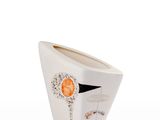 a white vase with a face on it on a white surface
