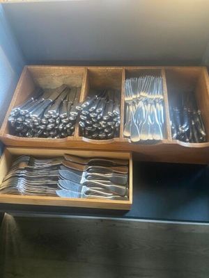 a lot of spoons and forks in a wooden box