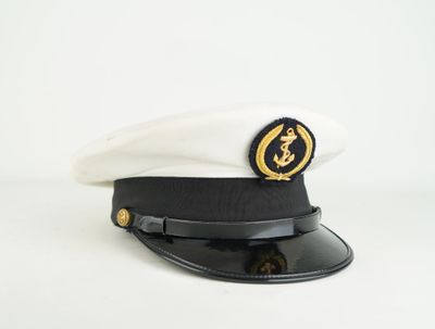 black and white hat with gold emblem on top of it