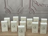 several boxes of ckk perfume sitting on a table in front of a wall