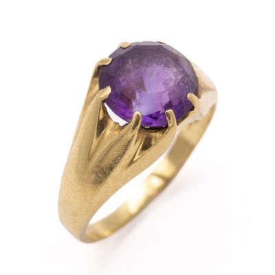 a close up of a gold ring with a purple stone