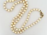gros plan d'un collier de perles sur une surface blanche