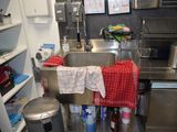 une cuisine équipée d'un évier, d'une poubelle et d'une poubelle