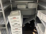 une petite pièce remplie d'étagères et de bacs