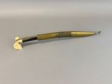 an image of a gold colored knife on a white surface