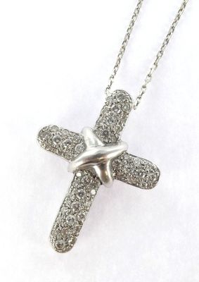 a close up of a silver cross on a chain on a white background