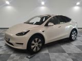 La Tesla Model X blanche est garée dans une pièce dont le sol est à carreaux.