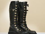 une paire de bottes en cuir noir ornées de boutons et de lacets dorés