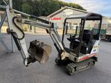 a small excavator that is parked in the parking lot