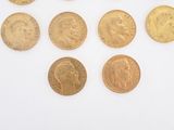 several different types of gold coins are arranged on a white surface
