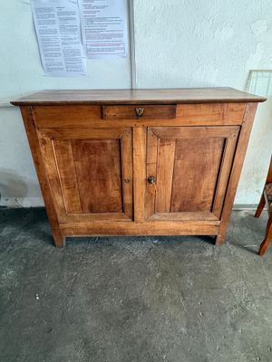 un petit meuble en bois muni d'une porte et d'une chaise