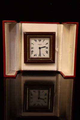 a small clock sitting in a box on a table
