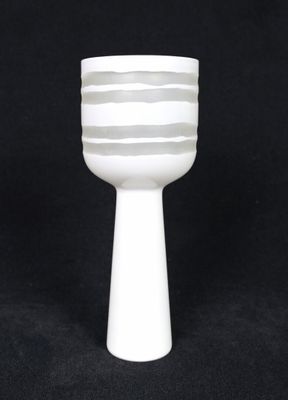 a white vase that is sitting on a black table