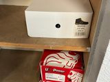 a white box sitting on top of a shelf in a closet