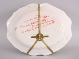 a white plate with a clock on it that has writing on it