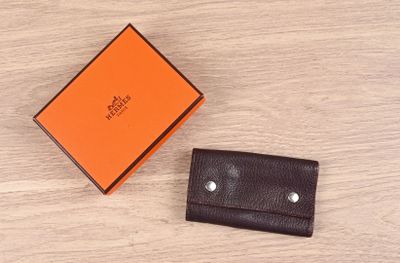 an orange box and a brown wallet on a wooden table