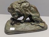 bronze statue of a lion on a base on a table