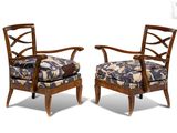 two chairs with floral upholstered cushions and a wooden frame