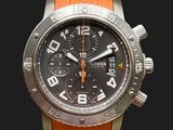 une montre orange avec un cadran noir sur fond noir