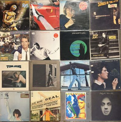 many different album covers on the wall of a room