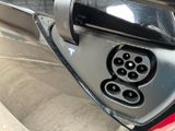 a close up of a car ' s rear end with a plugged in