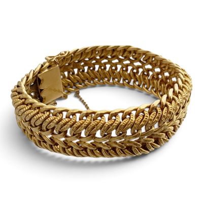 gros plan d'un bracelet en or sur fond blanc