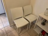 three white chairs in the corner of a room