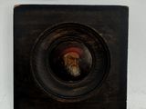 painting of an old man with a beard and a red hat in a black frame