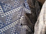 many shirts hanging on a rack in a closet