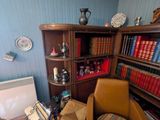 une chaise devant une bibliothèque sur laquelle sont posés de nombreux livres