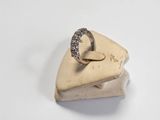 a gold ring with diamonds on it on a white surface