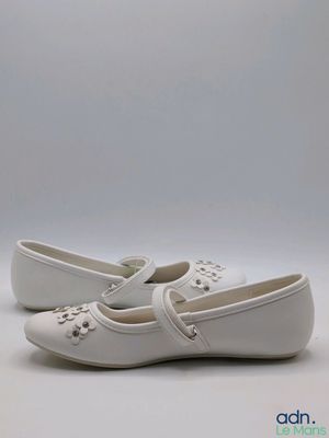 un gros plan sur une paire de chaussures blanches posées sur une surface blanche