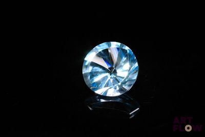 gros plan d'un diamant bleu sur une surface noire