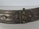 une image représentant une ceinture métallique ornée d'un motif