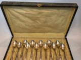 six silver spoons in a black case on a table
