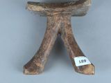 un petit tabouret en bois sur lequel est accrochée une étiquette