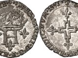 a silver coin with a cross on the front and a crown on the back