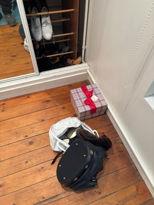 un sac noir posé par terre à côté d'un meuble à chaussures