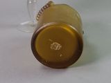 a brown glass with a gold rim on a white table